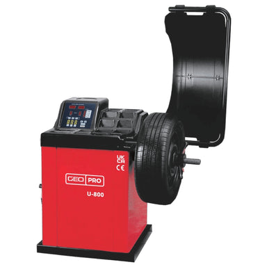 A red and black professional automotive wheel balancer, model U-800 by GEO, with a tyre mounted on the spindles and a black protective cover open behind it, shown against a plain white background.