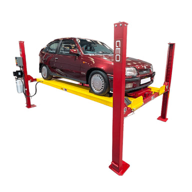 A red GEO four post storage lift with a yellow platform holding a dark red hatchback car, shown on a plain white background.