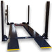Dark blue four post vehicle storage lift with yellow ramp tips on a lowered position on a white background